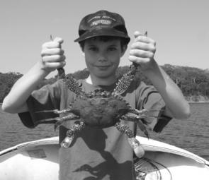Young Jason Earl proudly displays one of the big blue swimmer crabs he and his Dad have been catching. There should still be time for the blueys and a mullet head is the top bait.